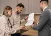 Para w kuchni ogląda z doradcą dokumenty dotyczące mieszkania