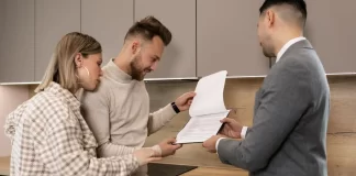 Para w kuchni ogląda z doradcą dokumenty dotyczące mieszkania