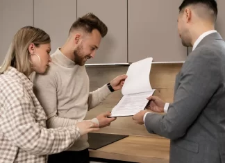 Para w kuchni ogląda z doradcą dokumenty dotyczące mieszkania