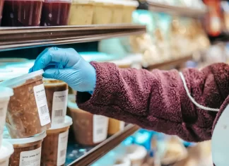 Czym różni się alergia pokarmowa od nietolerancji? Osoba w supermarkecie sięga po gotowy produkt z etykietą